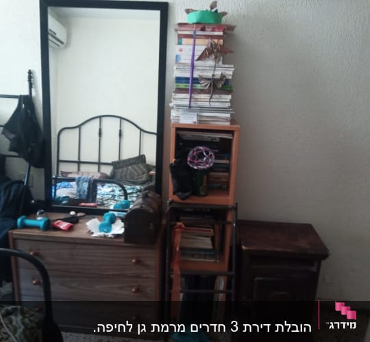 חדר עם רהיטים, מראה וספרים על מדף
